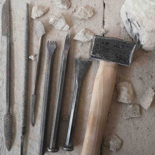 Carving tools laid out amount chunks of stone