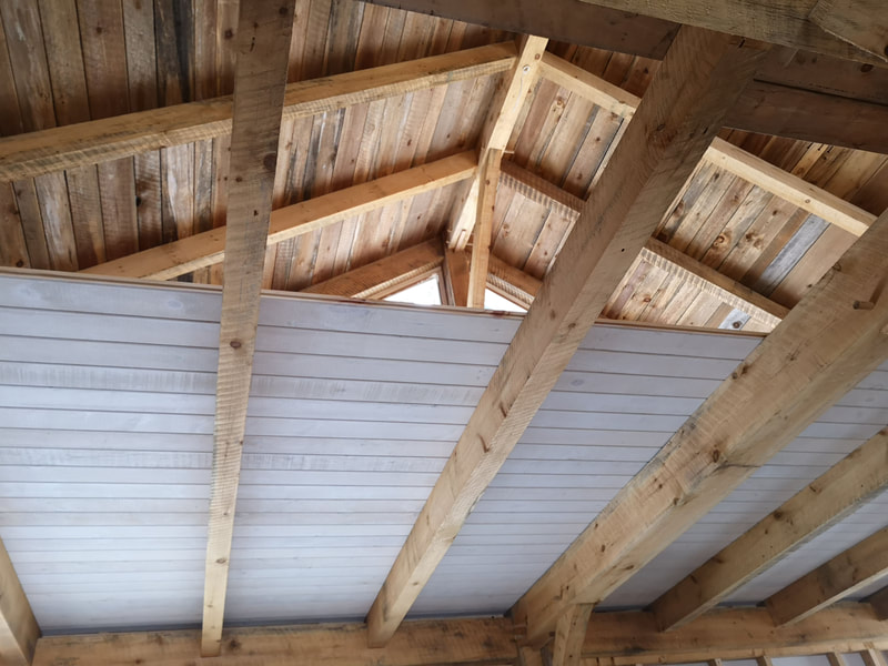 Inside of a timber frame structure with ceilings being put into place.