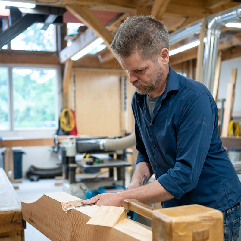 Cirvan Hamilton working in the studio carving lumber with hand tools